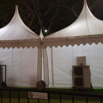 white pagoda tent at night, close-up on twin peaks, portable speaker equipment at base, dark trees background