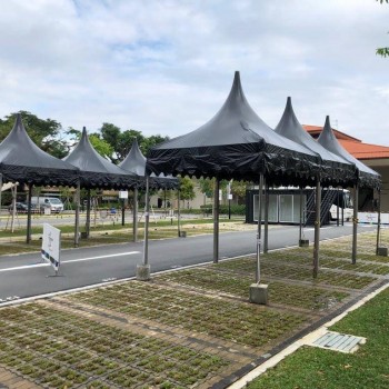 black pagoda tents in a row on paved outdoor path, residential estate setting, empty, daytime